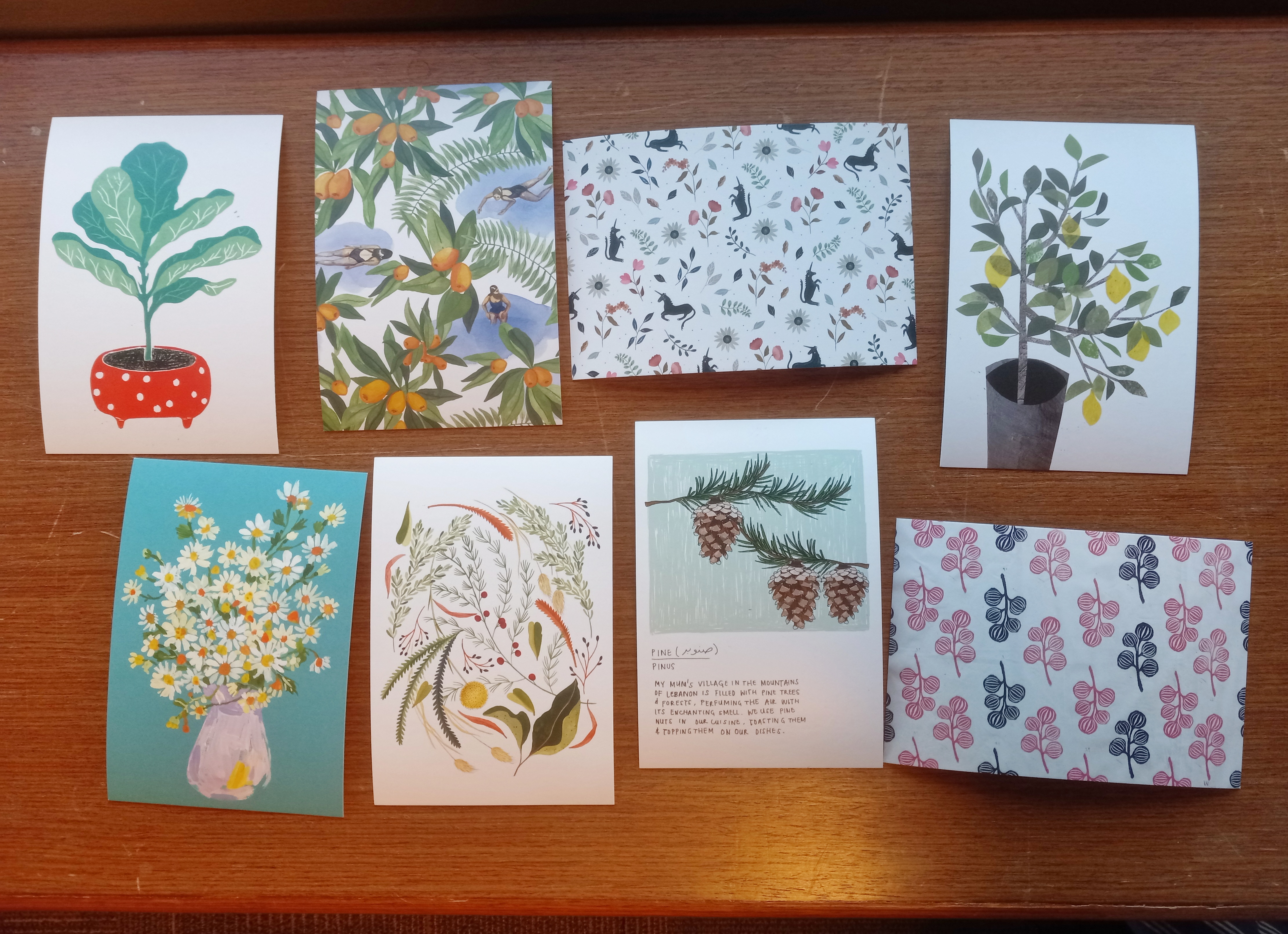 Eight floral postcards laid out on a table