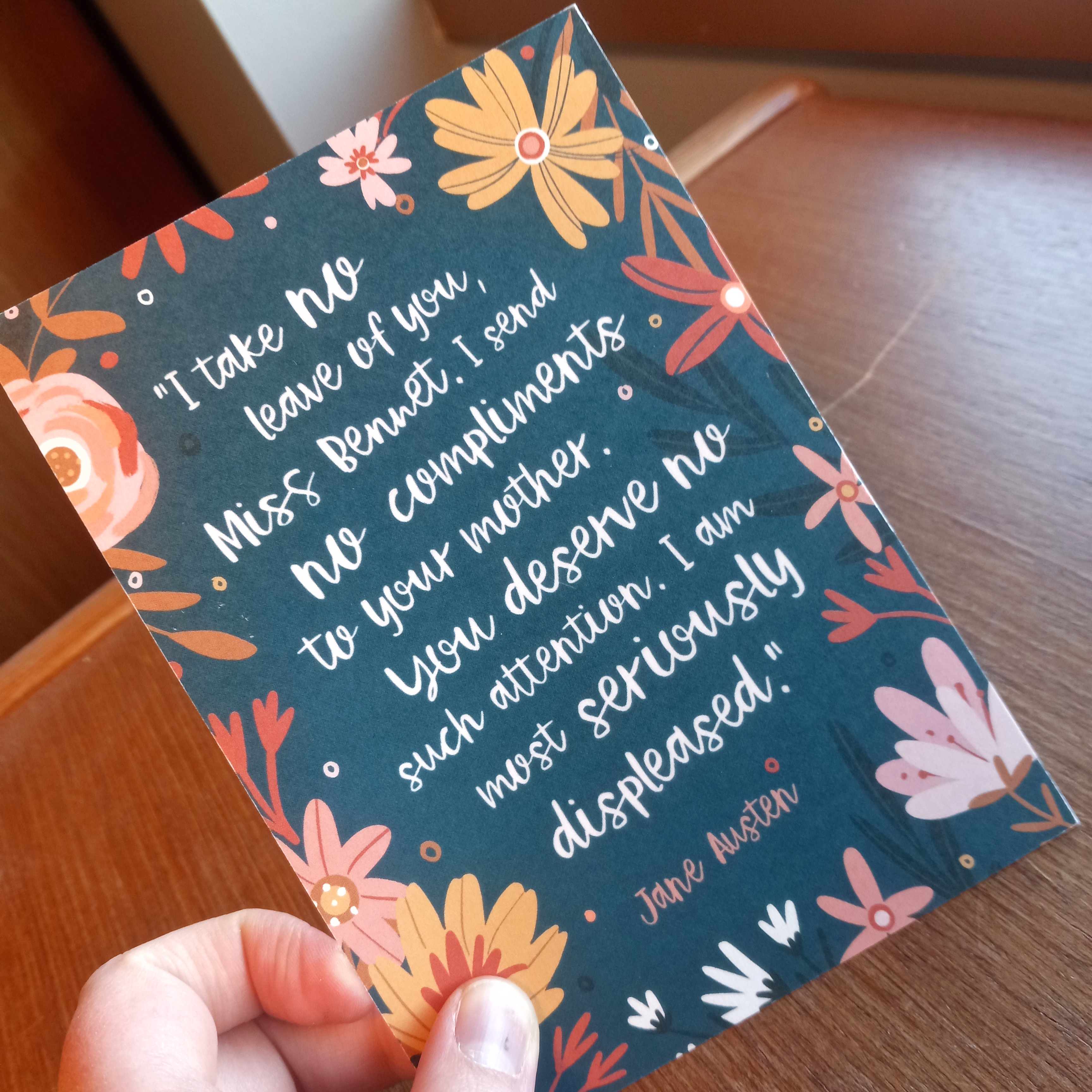 A postcard with the quote: "I take no leave of you, Miss Bennet. I send no compliments to your mother. You deserve no such attention. I am most seriously displeased." - Jane Austen