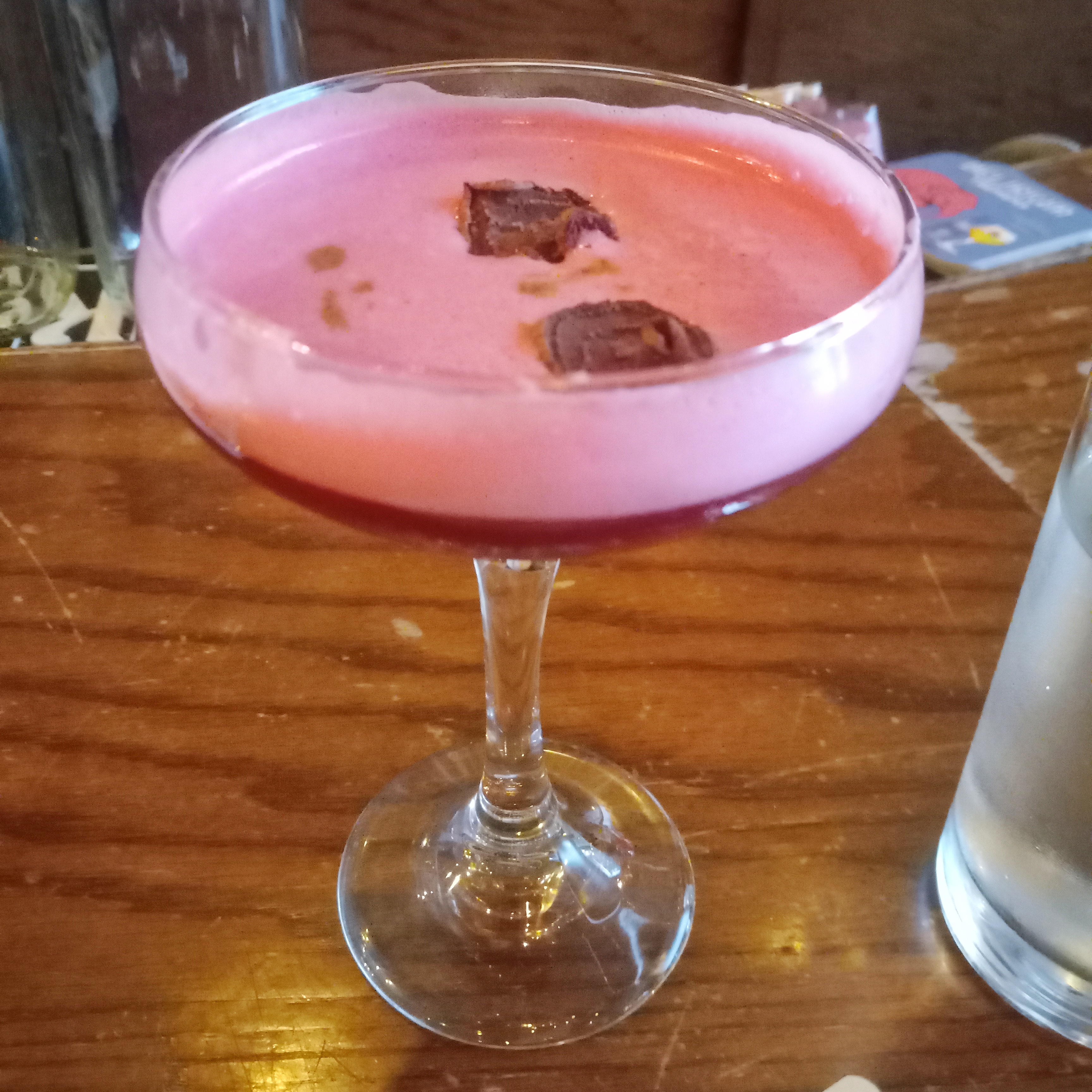 A pink cocktail garnished with dried beet slices